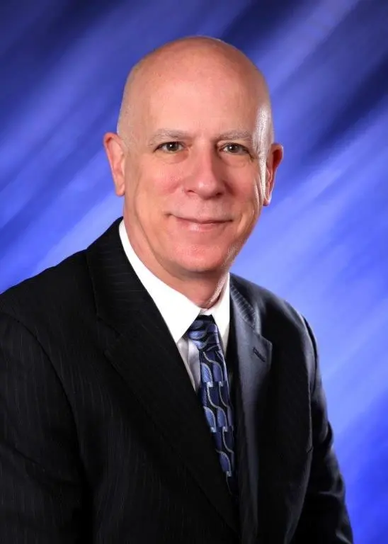 Dr. Donald Reno, smiling in a dark suit